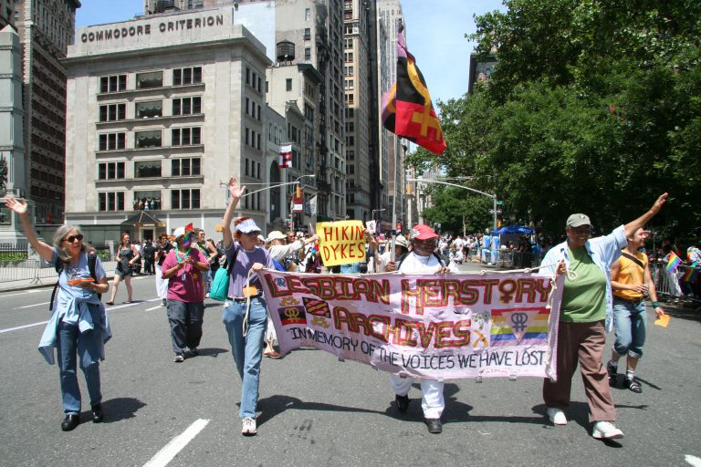 Lesbian Herstory Archives Coordinators Hold a sign during a march